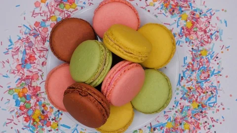Colorful macarons are rotating on white plate. Top view. Stock Footage 106984834