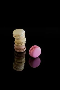 Colorful macarons with reflection isolated on a black background. Sweet Frenc Stock Photos