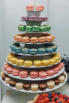 Colorful macarons stack elegantly on tiered stand 스톡 사진