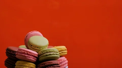 A colorful macaroons are rotating on red background Stock Footage 106985578