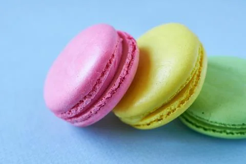 Colorful macaroons on blue background. Selective focus. Stock Photos