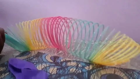 Colorful magic rainbow spring toy stretching dynamically with vibrant coils Stock Footage 334547774