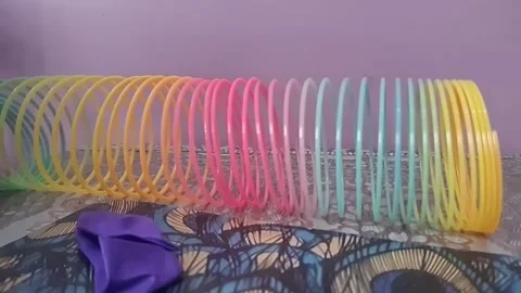 Colorful magic rainbow spring toy stretching dynamically with vibrant coils, Stock Footage 334547789