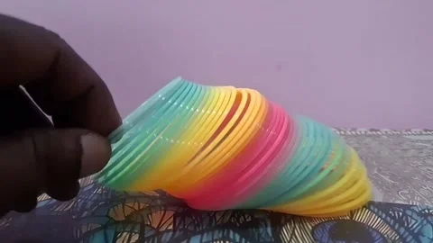 Colorful magic rainbow spring toy stretching dynamically with vibrant coils, Stock Footage 334547790