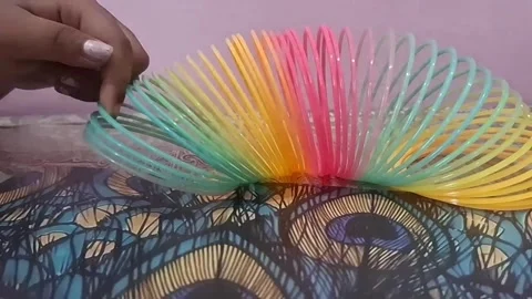 Colorful magic rainbow spring toy stretching dynamically with vibrant coils, Stock Footage 334548504