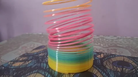 Colorful magic rainbow spring toy stretching dynamically with vibrant coils, Stock Footage 334554423