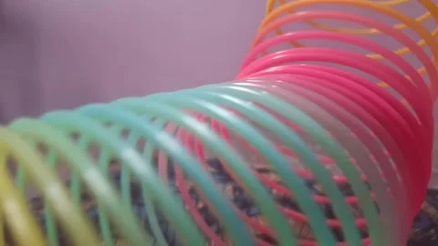 Colorful magic rainbow spring toy stretching dynamically with vibrant coils, Stock Footage 334554431