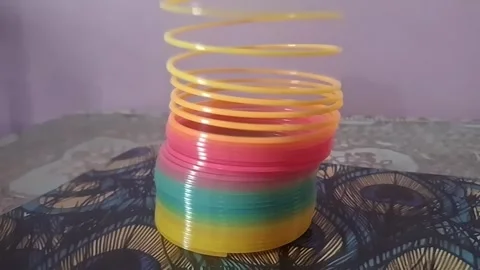 Colorful magic rainbow spring toy stretching dynamically with vibrant coils, Stock Footage 334554519