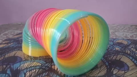 Colorful magic rainbow spring toy stretching dynamically with vibrant coils, Stock Footage 334554522