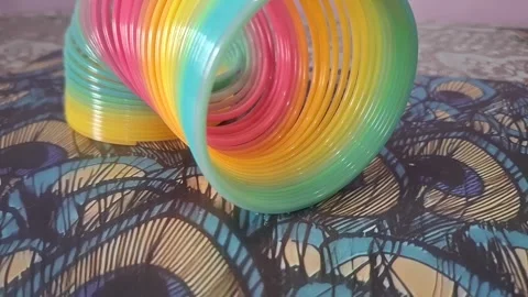 Colorful magic rainbow spring toy stretching dynamically with vibrant coils, Stock Footage 334554643