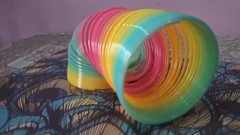Colorful magic rainbow spring toy stretching dynamically with vibrant coils, Stock Footage 334554644