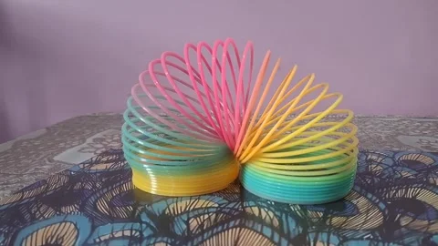 Colorful magic rainbow spring toy stretching dynamically with vibrant coils, Stock Footage 334554652