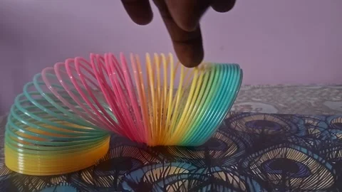 Colorful magic rainbow spring toy stretching dynamically with vibrant coils Stock Footage 334554736
