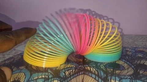 Colorful magic rainbow spring toy stretching dynamically with vibrant coils Stock Footage 334554737