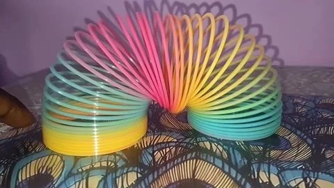Colorful magic rainbow spring toy stretching dynamically with vibrant coils Stock Footage 334554776
