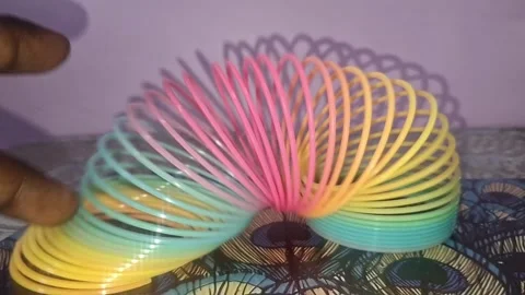 Colorful magic rainbow spring toy stretching dynamically with vibrant coils Stock Footage 334554779