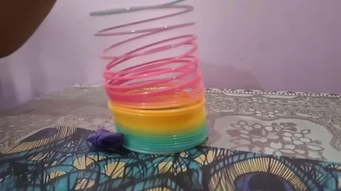 Colorful magic rainbow spring toy stretching dynamically with vibrant coils Stock Footage 334554818