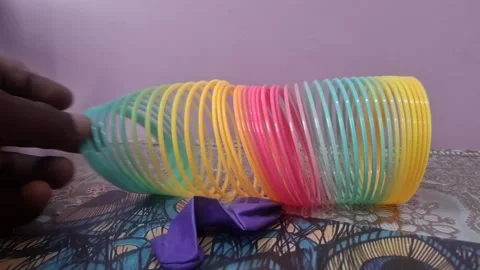 Colorful magic rainbow spring toy stretching dynamically with vibrant coils Stock Footage 334554975