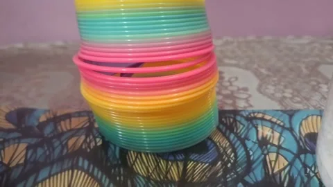 Colorful magic rainbow spring toy stretching dynamically with vibrant coils Stock Footage 334555001