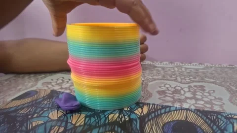 Colorful magic rainbow spring toy stretching dynamically with vibrant coils Stock Footage 334555002