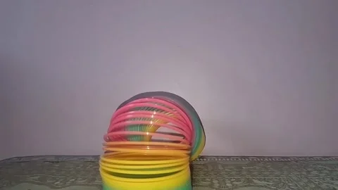 Colorful magic rainbow spring toy stretching dynamically with vibrant coils Stock Footage 334555064