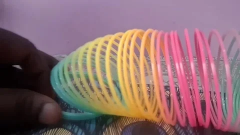 Colorful magic rainbow spring toy stretching dynamically with vibrant coils Stock Footage 334555072