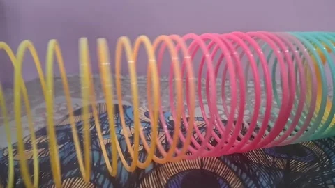Colorful magic rainbow spring toy stretching dynamically with vibrant coils Stock Footage 334555090