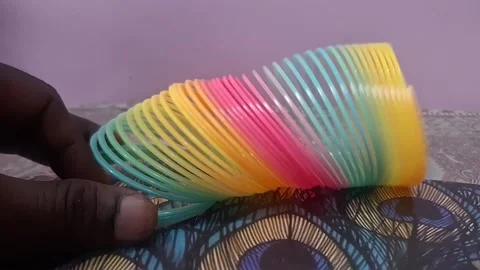 Colorful magic rainbow spring toy stretching dynamically with vibrant coils Stock Footage 334555098