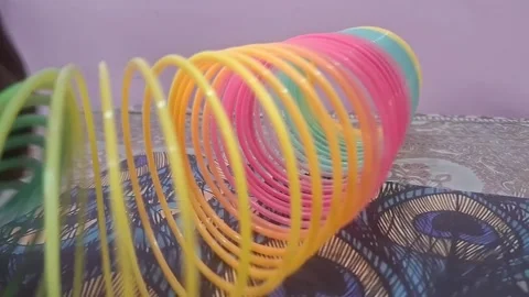 Colorful magic rainbow spring toy stretching dynamically with vibrant coils Stock Footage 334555105