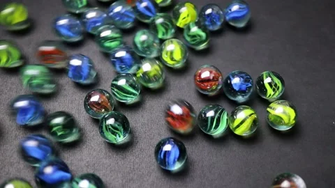 Colorful marbles rolling on a black background Stock Footage 160309265