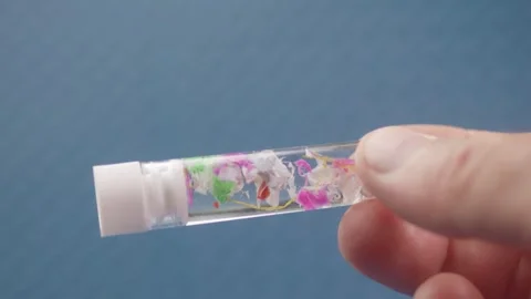 Colorful microplastic bits in a lab test tube, focusing on sample testing f.. Vidéo 290353920