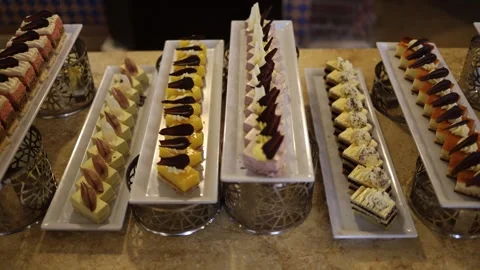 Colorful mini cakes dessert selection creamy layers fruit glaze chocolate toppin Stock Footage 310536212