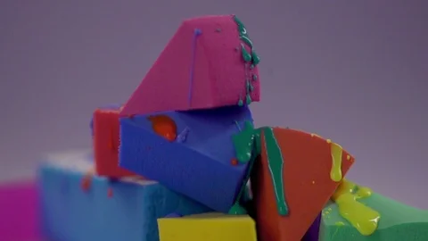 Colorful nail polish flows down the surface of the make-up sponge. Video stock 77512125