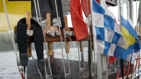 Colorful nautical sailing flags flying in the wind from the lines of a sailboat Stock Footage 75081145