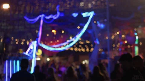 Colorful neon lights shaping dynamic night market moment, relaxed crowd and soft Stock Footage 321817631