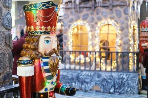 Colorful nutcracker decoration stands in front of a charming fairytale town Stock Photos