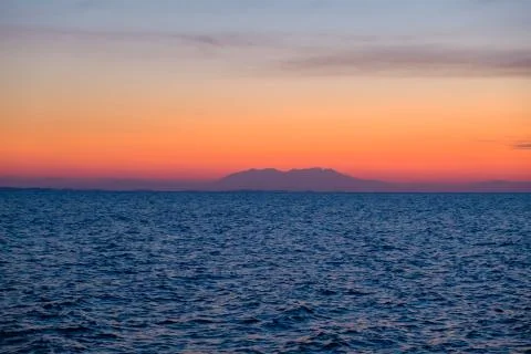 Colorful orange sunset over a island  Stock Photos