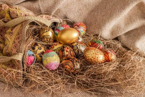 Colorful painted easter egg from fabric bag on hay Foto stock