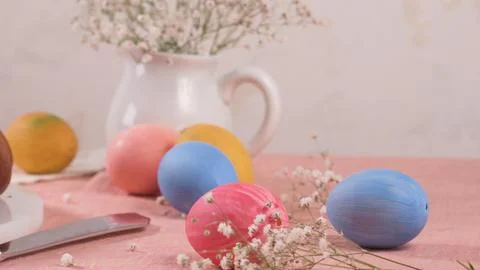 Colorful Painted Easter Eggs and Spring Gypsophila Flowers on Pink Linen 스톡 사진