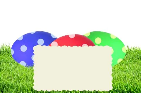 Colorful Painted Easter Eggs in green grass and card isolated on white 库存照片