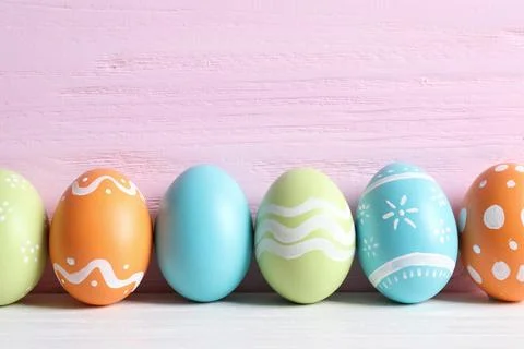 Colorful painted Easter eggs on table against wooden background, space for te Stock Photos
