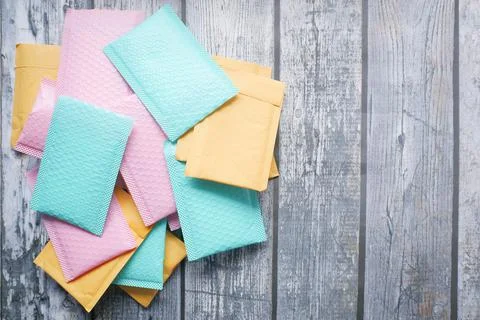 Colorful paper bubble envelope on table Stock Photos