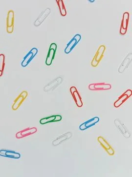 Colorful paper clips pattern on white background Stock Photos