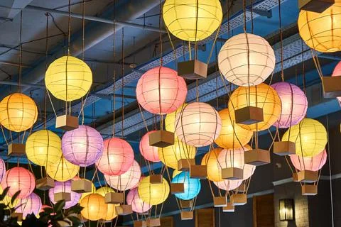 Colorful paper lanterns hang on ceiling in the mall Stock Photos