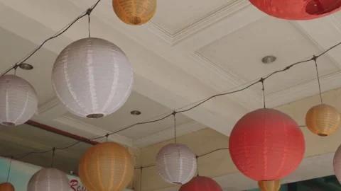 Colorful paper lanterns hanging from a ceiling for celebration decoration. 库存影片 343369633