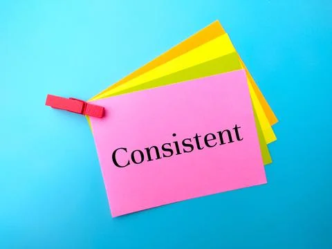 Colorful paper note with text Consistent on a blue background. Foto stock