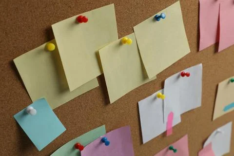 Colorful paper notes pinned to cork board Stock Photos