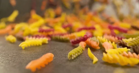 Colorful Pasta falling on table surface Closeup 4K Stock Footage 104052352