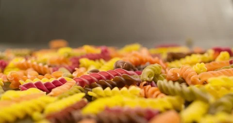 Colorful Pasta Macaroni falling pouring on table surface 4K Stock Footage 104060322