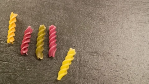 Colorful Pasta Macaroni rolling on Table Closeup Slow motion Stock Footage 104063078